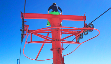 skier sitting on ski lift pole